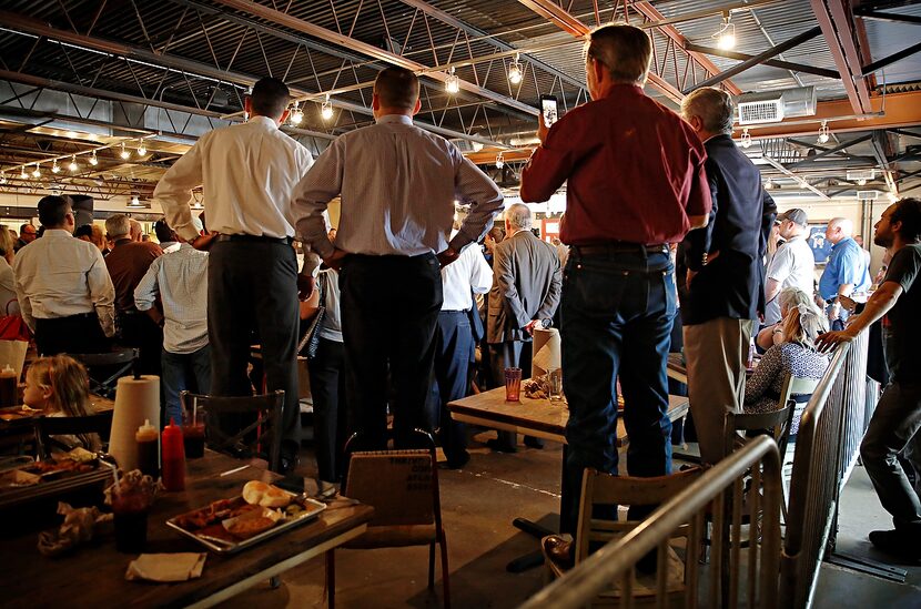 
Men stand on their chairs to catch a glimpse of Texas Gov. Greg Abbott as he speaks to a...