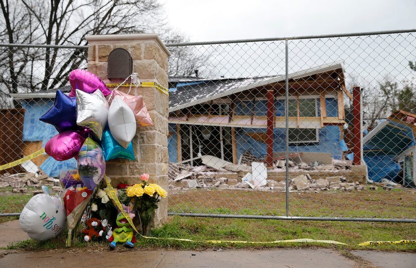 Flowers and balloons were left in front of the house along Espanola Drive in northwest...