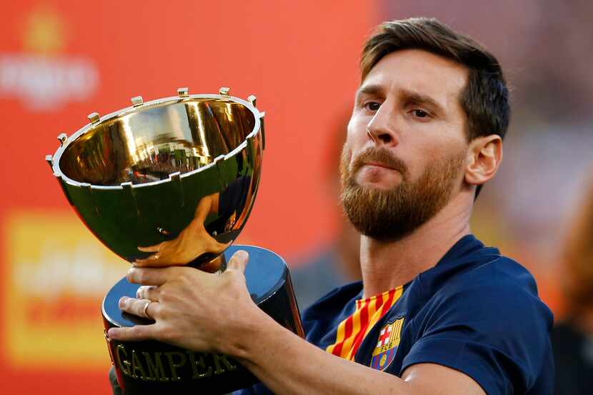 El delantero argentino Lionel Messi del Barcelona sostiene el trofeo Joan Gamper tras el...