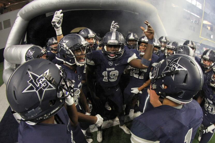 Members of the Frisco Lone Star Rangers get fired up just before storming onto the field to...