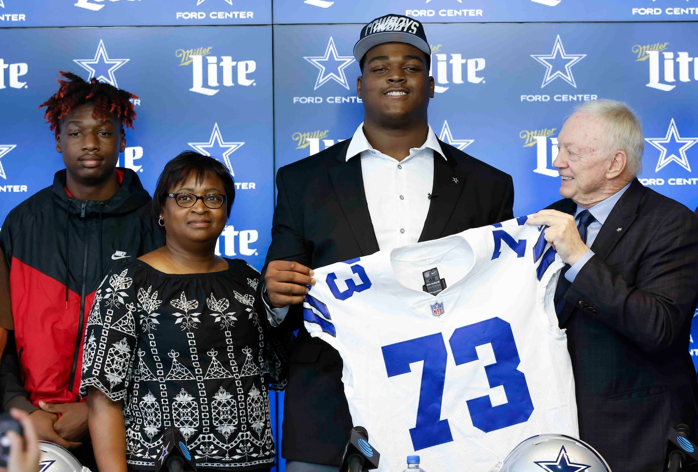 Dallas Cowboys first round draft pick Tyler Smith of Tulsa, center, poses for a photo with...