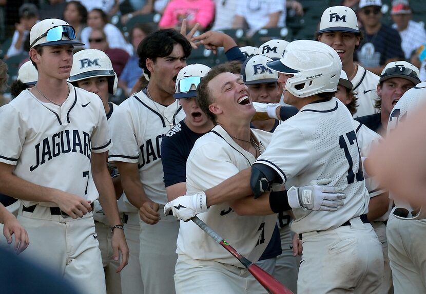 Flower Mound Sam Erickson, (21), celebrates with Zane Becker, (17), and teammates after...