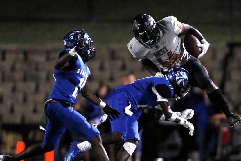 West Mesquite's Canaan Dirden (44) is knocked off his feet by North Mesquite defensive back...