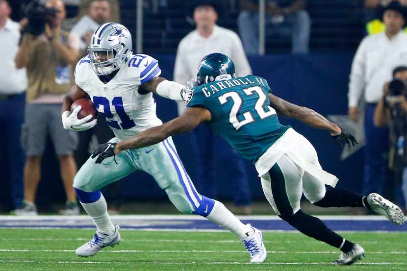 Dallas Cowboys running back Ezekiel Elliott (21) gives a stiff arm to Philadelphia Eagles...