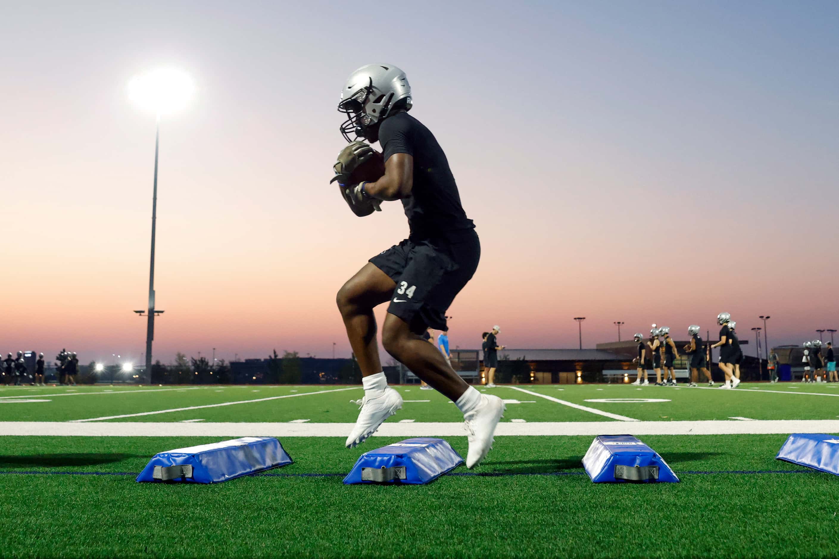 Running back Jed Ogunranti runs a drill during an early morning practice at Panther Creek...