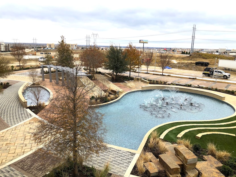 The first buildings at the Realm surround a landscaped plaza with fountains.