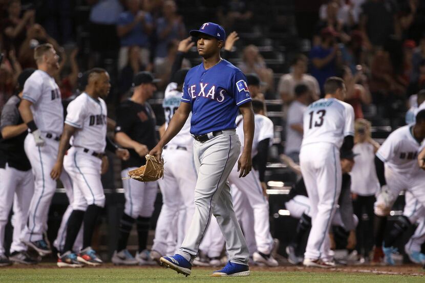 Texas Rangers relief pitcher Jose Leclerc walks off the field after giving up a walk-off,...