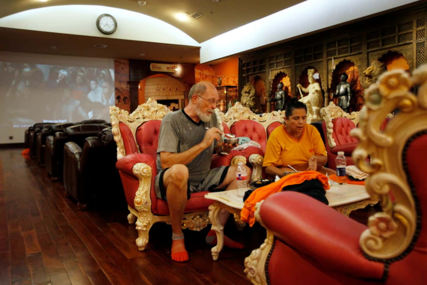 Allen Olson, left, and Rosemary Rivera have dinner while watching a basketball game inside...