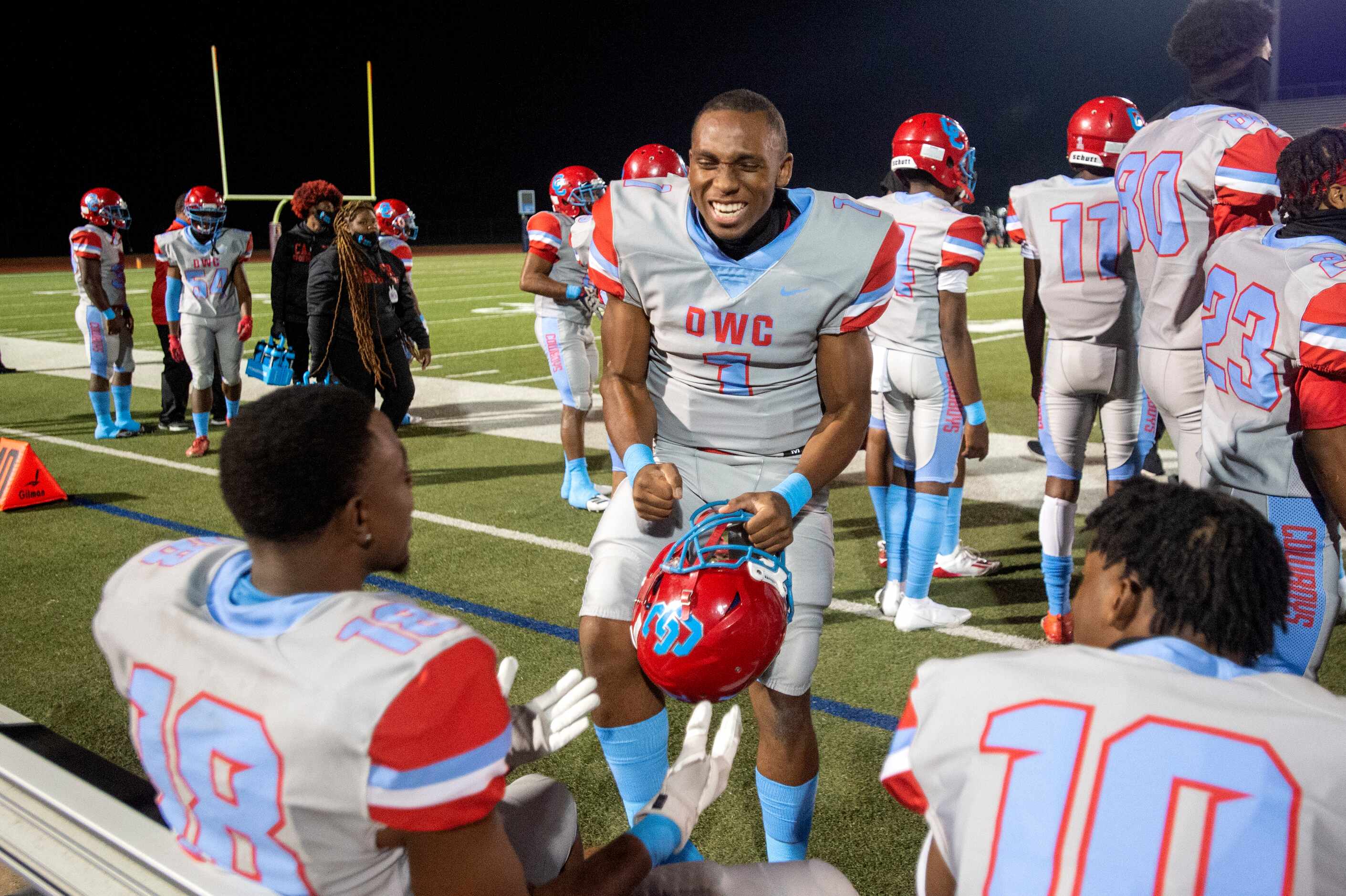 Carter senior quarterback Kace Williams (1) jokes on the sidelines with senior wide receiver...