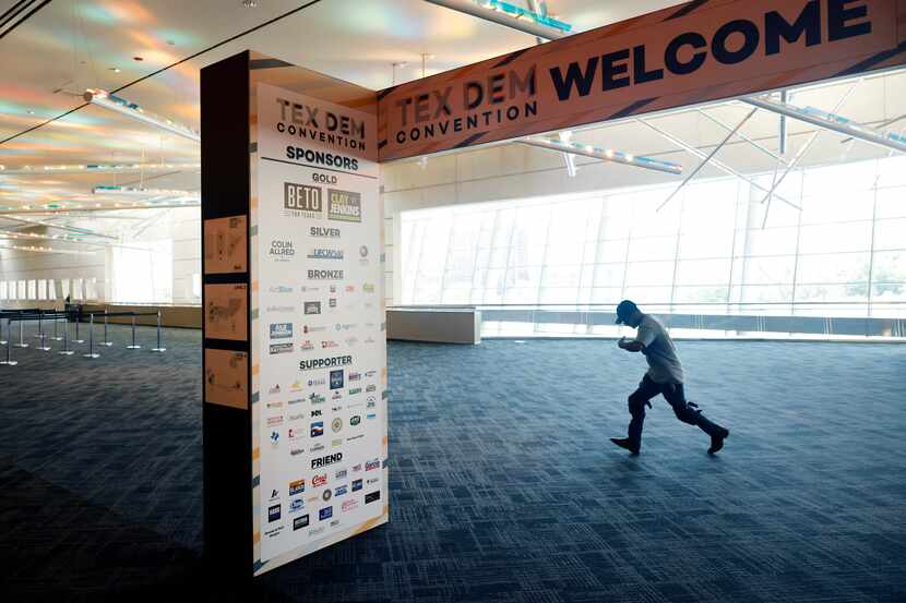 A crewman hustles to the exhibit hall as people set up ahead of the 2022 Texas Democratic...