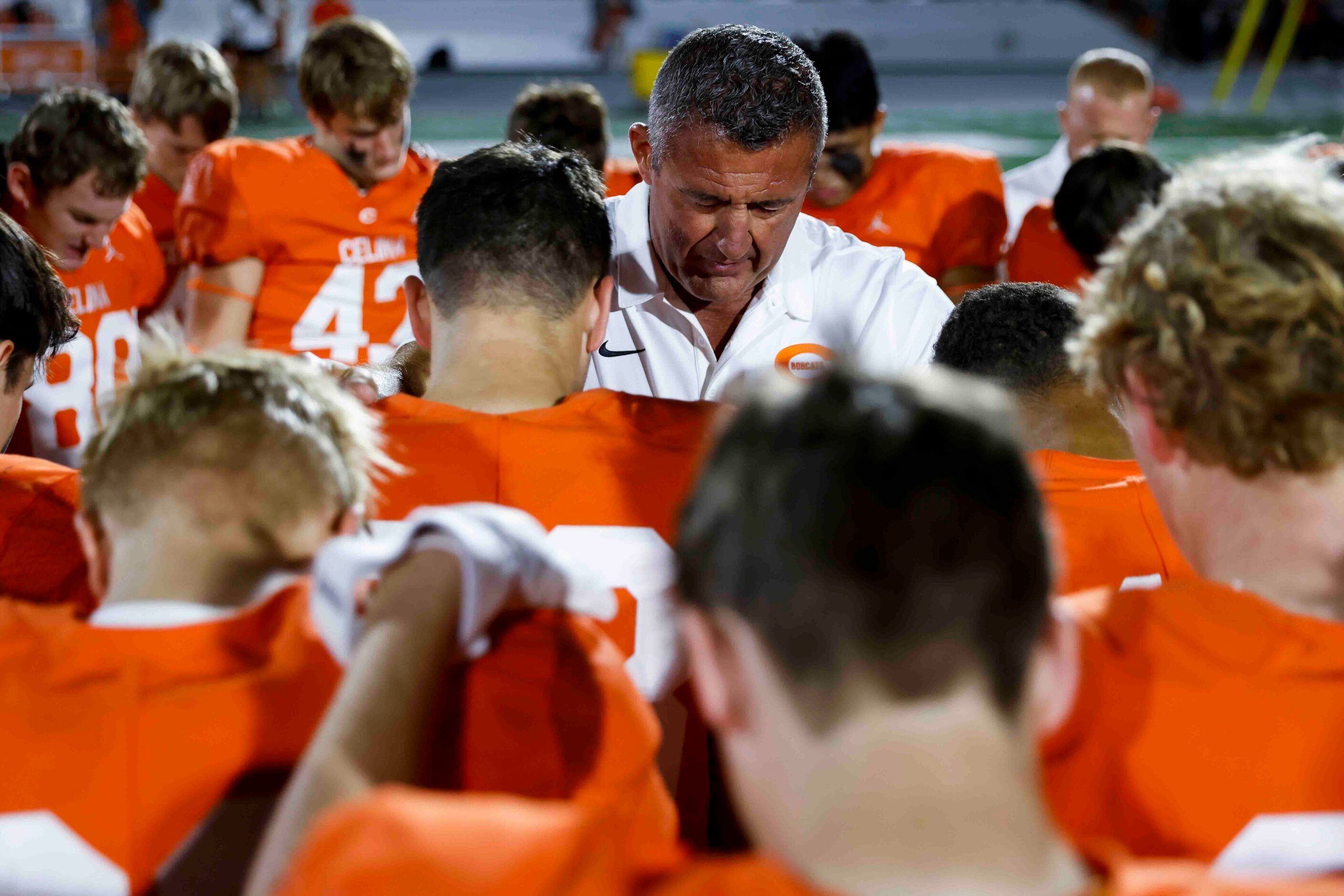 Celina head coach Bill Elliott prays with his team after winning against David W. Carter...