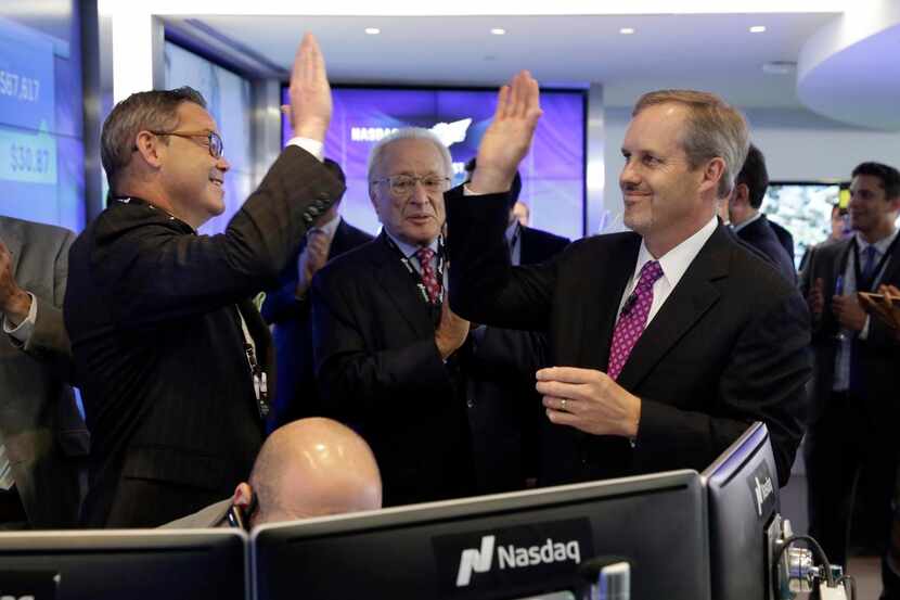 
CEO Charles Morrison (right) gave a high five as Wingstop’s shares began trading on the...