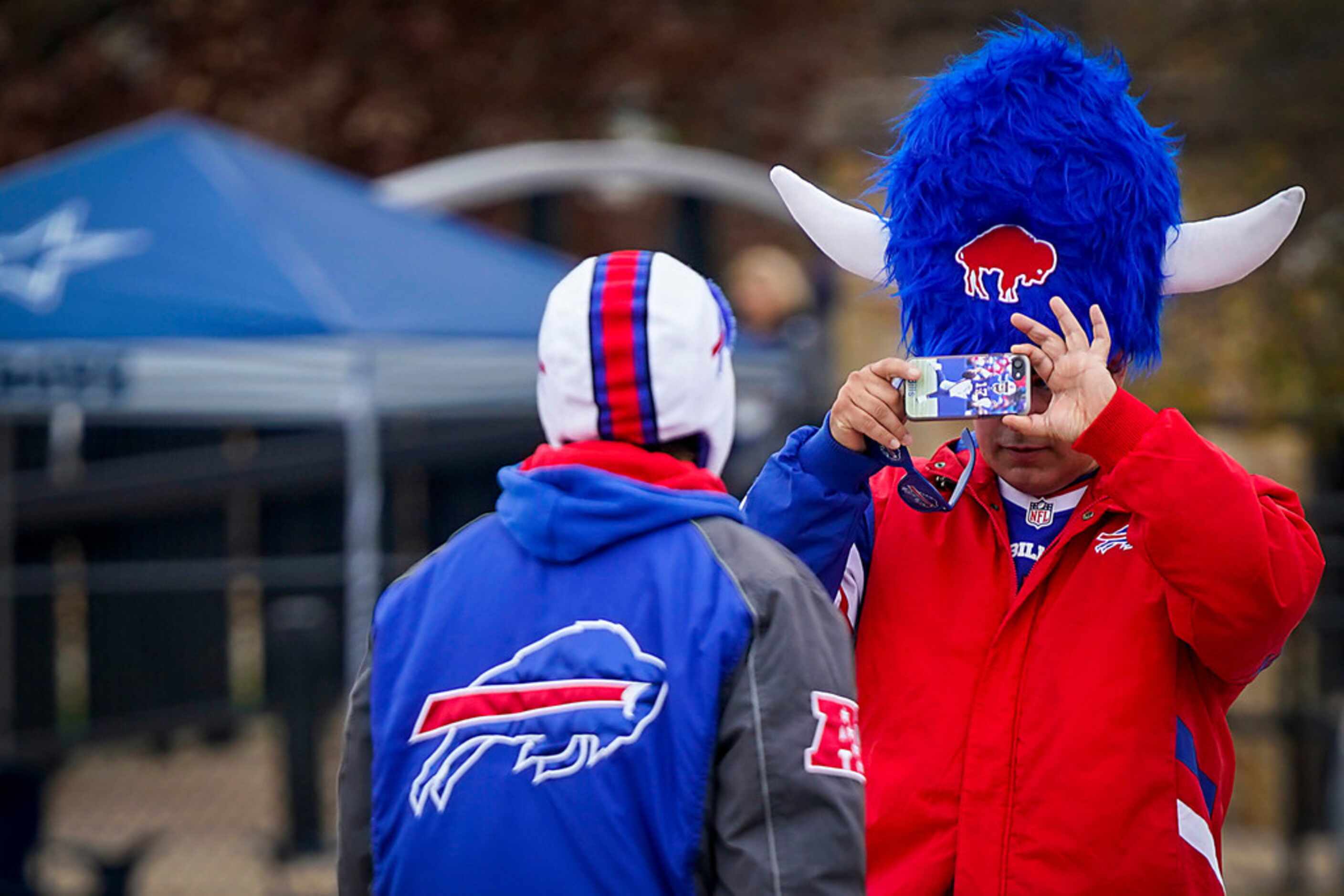 Buffalo Bills fan Sam Huerta takes a photo of Diana Medina as fans tailgate before an NFL...