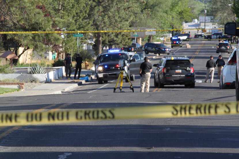 Investigators work along a residential street following a deadly shooting Monday, May 15,...