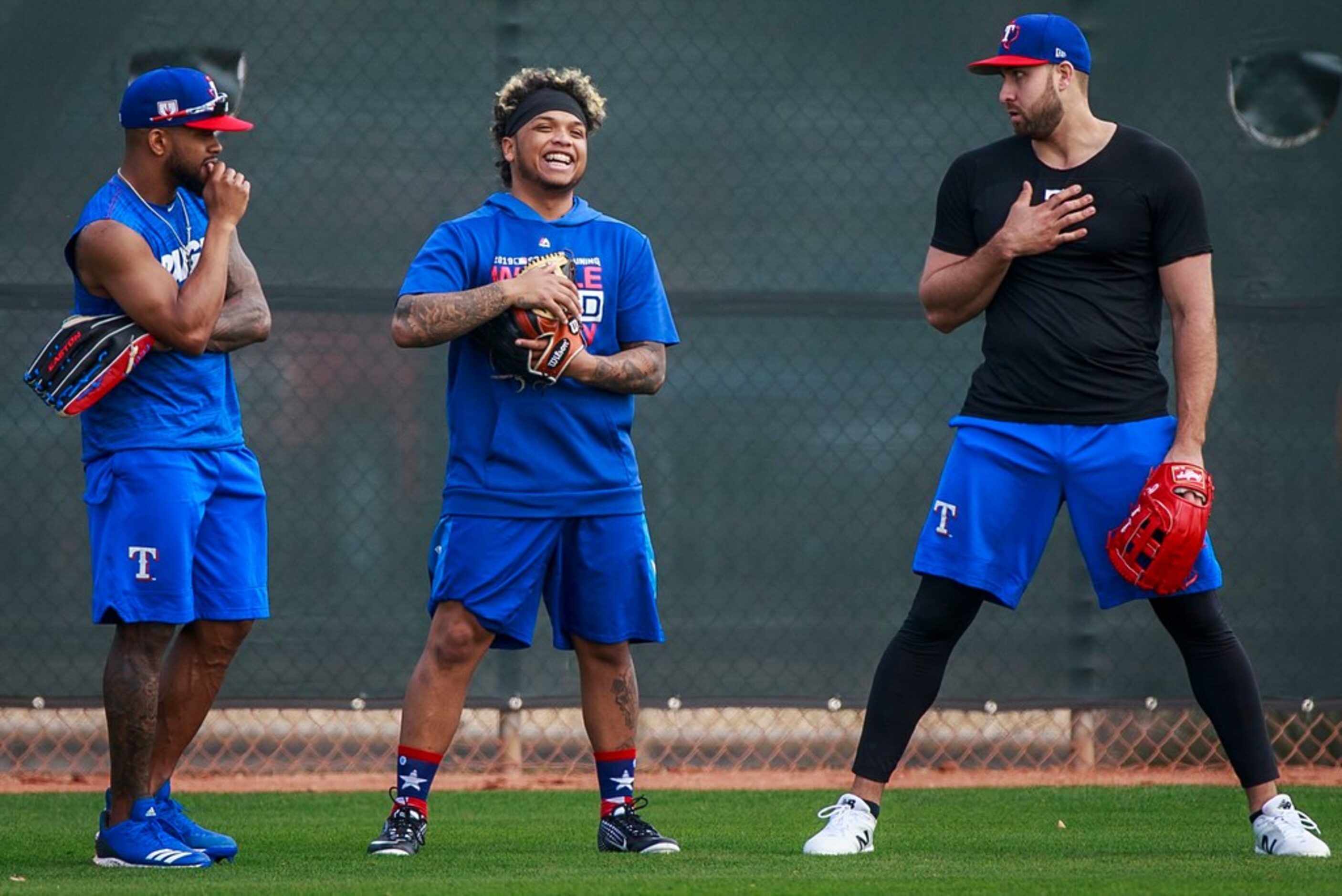 Texas Rangers outfielder Willie Calhoun (center) laughs with Delino DeShields (left) and...