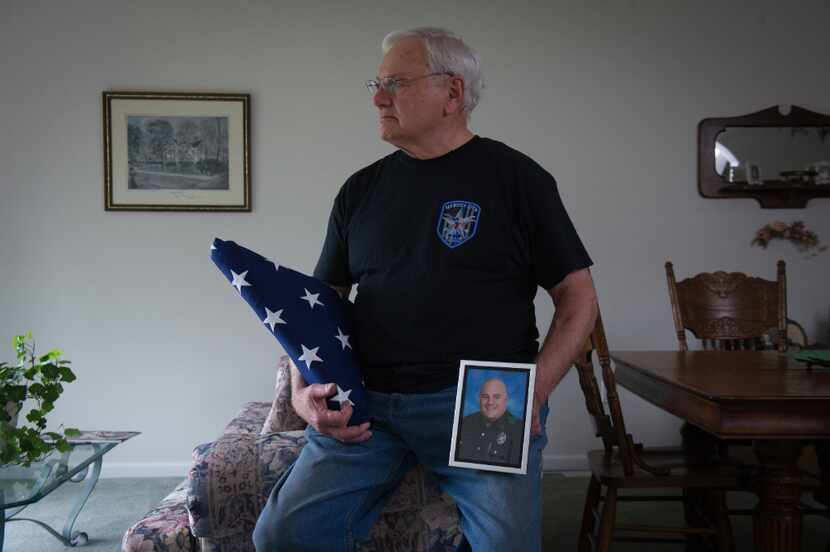William Ahrens holds a portrait of his son Lorne Ahrens, who was killed in the line of duty...