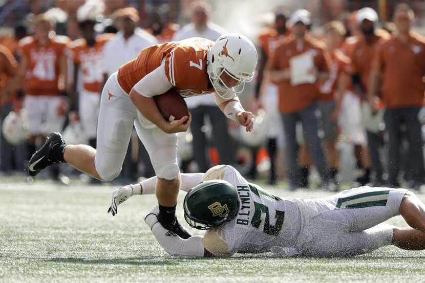 Texas quarterback Shane Buechele (7) is tripped by Baylor safety Blake Lynch (21) during the...