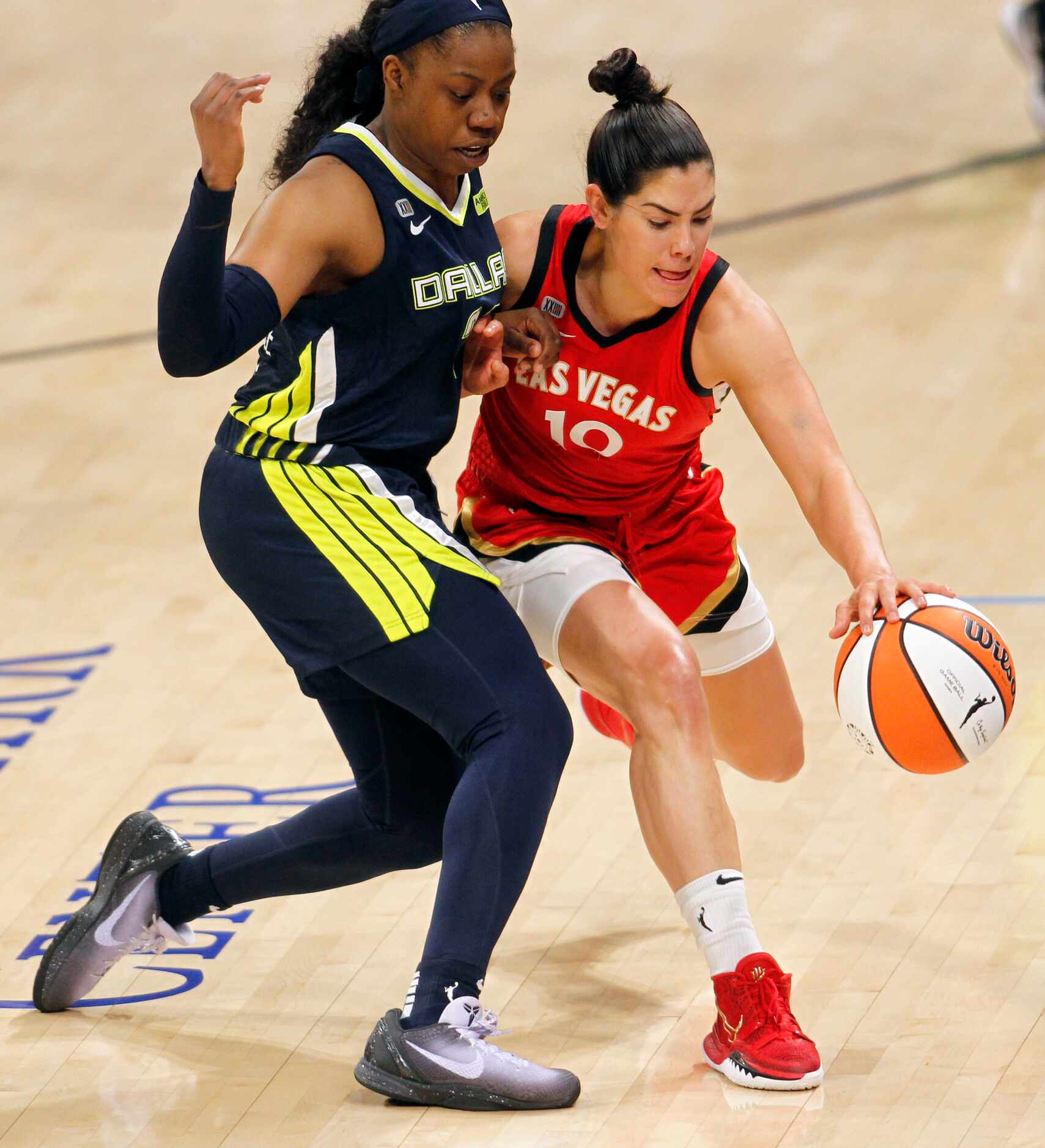 Las Vegas guard Kelsey Plum (10) attempts to dribble around the defense of Dallas guard...