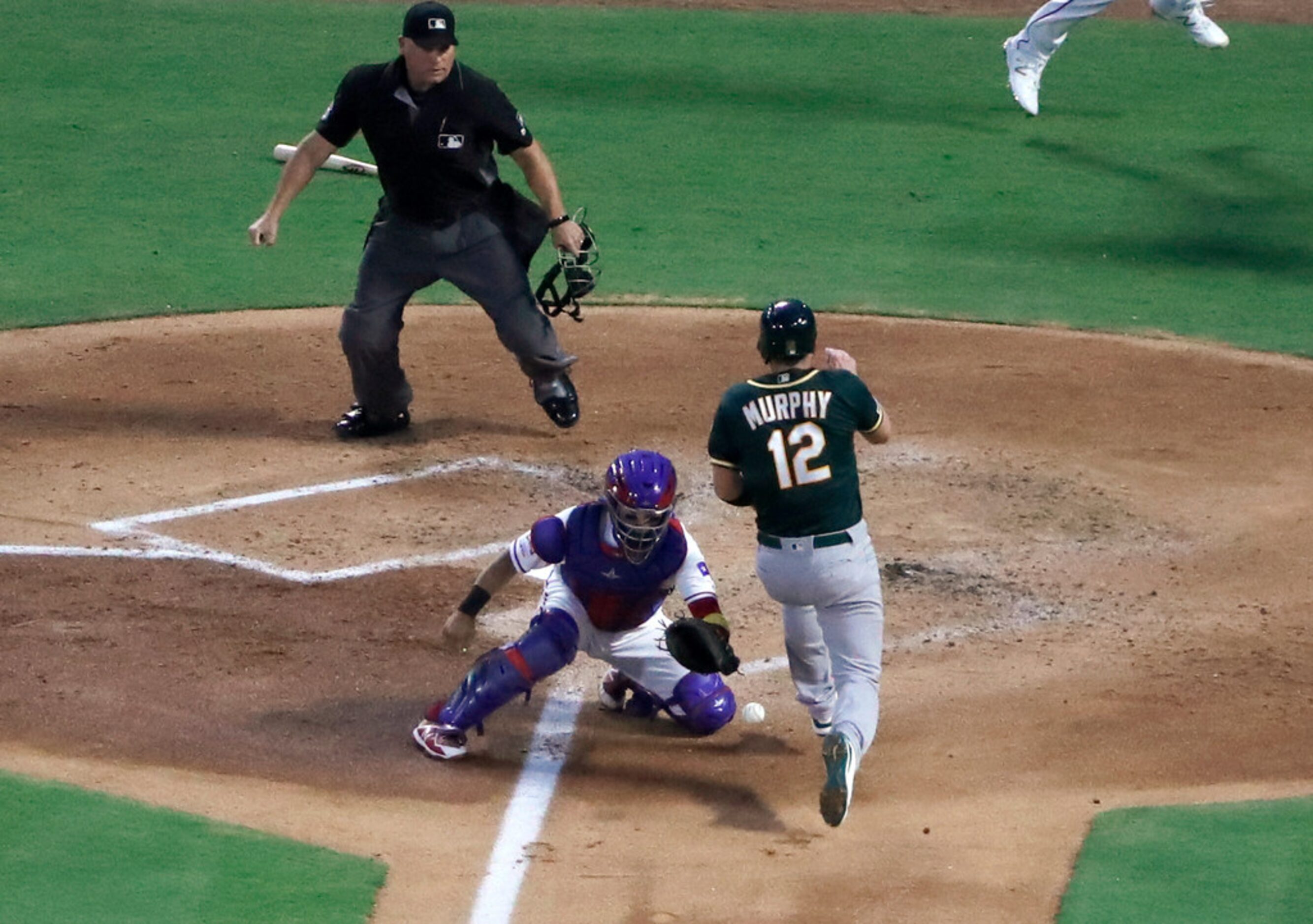 Texas Rangers catcher Jose Trevino misses the throw to the bag as Oakland Athletics' Sean...