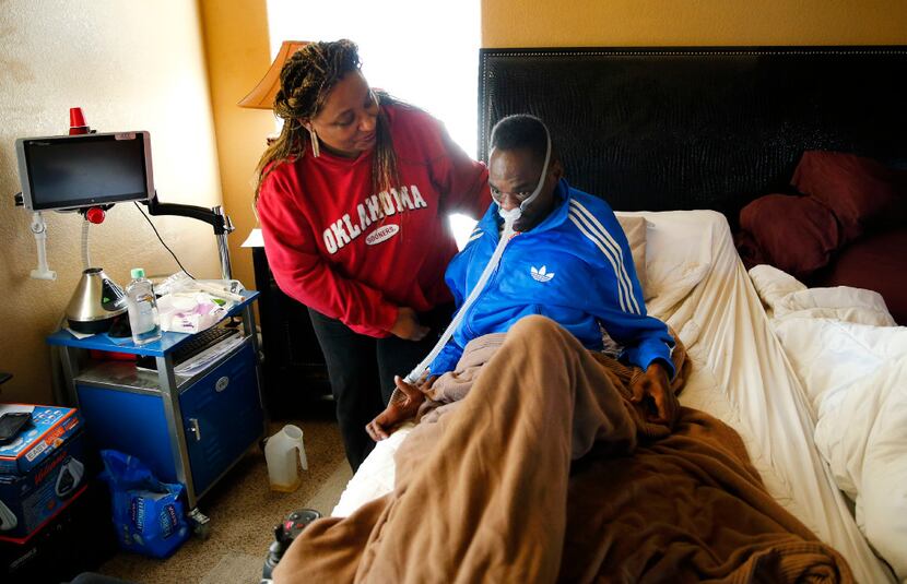Former NFL player Rickey Dixon gets help sitting up from his wife, Lorraine, as he rests in...