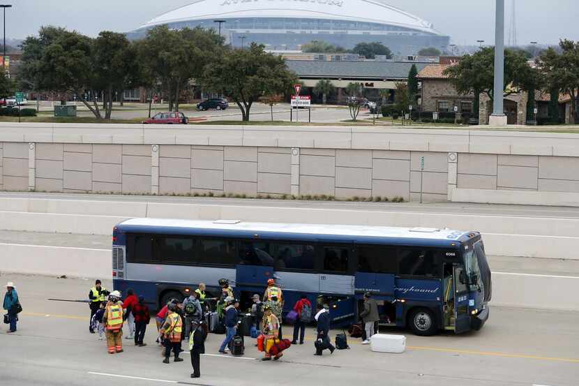 Policías y bomberos de Arlington ayudan a los pasajeros de un autobús que chocó contra una...