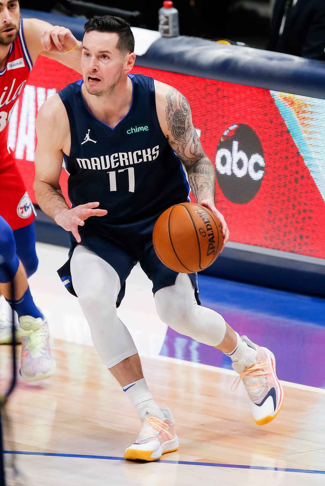 Dallas Mavericks guard JJ Redick (17) looks for room against the Philadelphia 76ers defends...