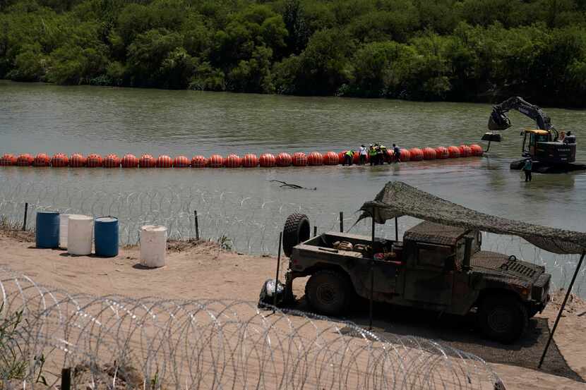 Workers assemble a floating border barrier in the Rio Grande in Eagle Pass, Texas, on, July...