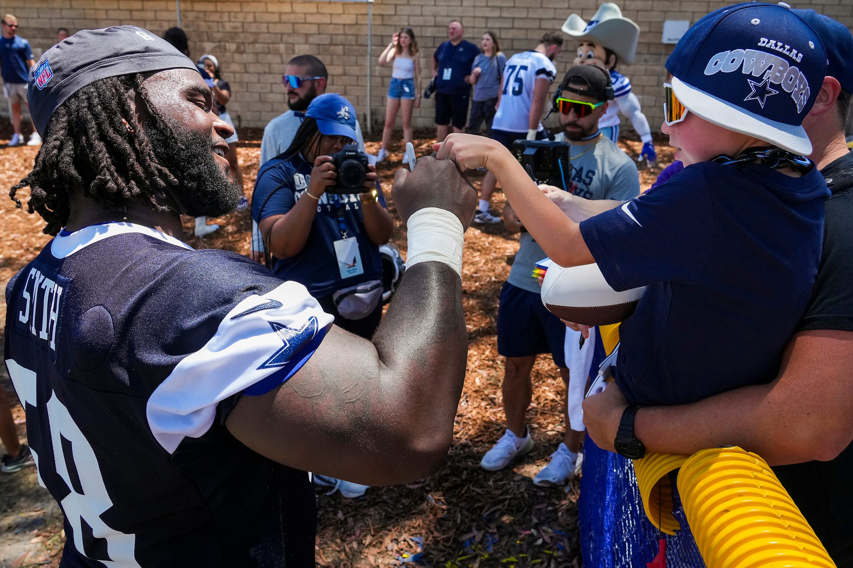 Dallas Cowboys defensive tackle Mazi Smith (58) first bumps with a young fan following the...