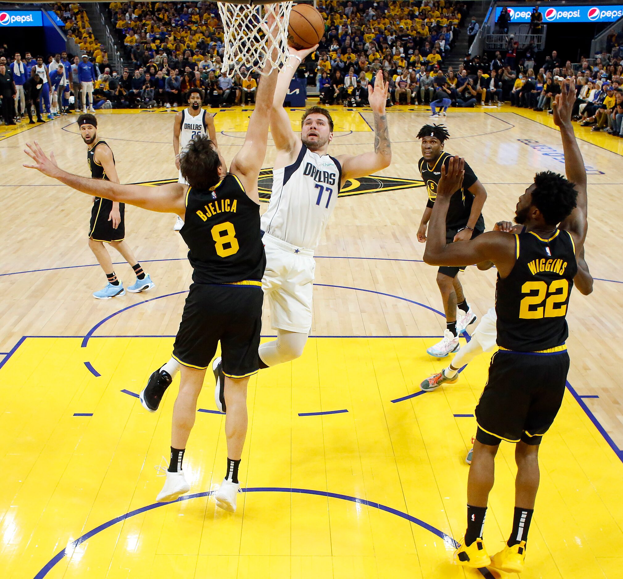 Dallas Mavericks guard Luka Doncic (77) takes an off-balance shot against Golden State...