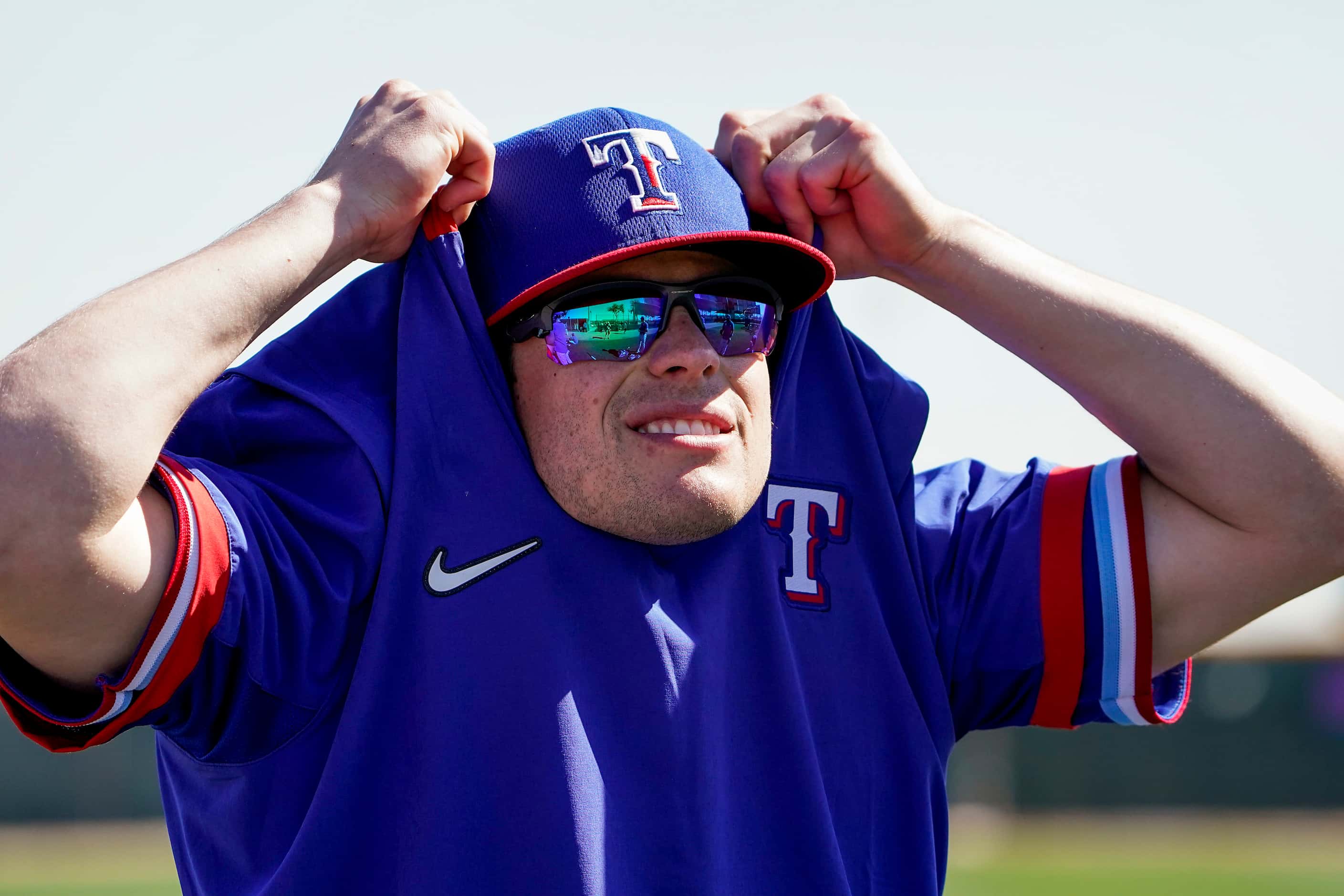 Texas Rangers infielder Nick Solak (takes off his warmup during a spring training workout at...