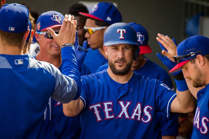 Texas Rangers infielder Trevor Plouffe is welcomed into the dugout after hitting a solo home...