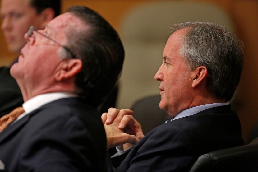 Texas Attorney General Ken Paxton (right) and his attorney Dan Cogdell sit at the defense...