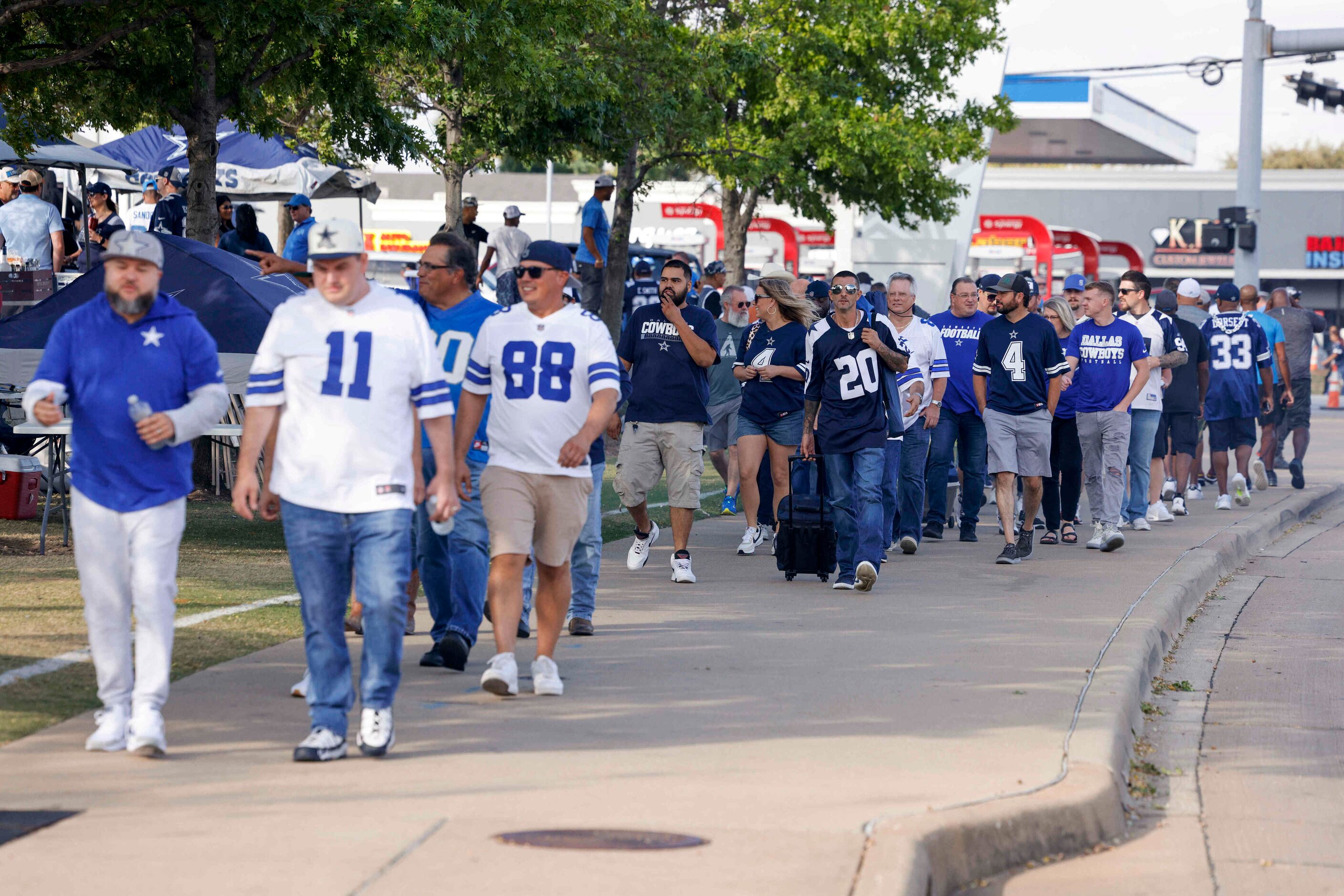 Football fans walk along Randol Mill Road before a Dallas Cowboys and Detroit Lions game at...