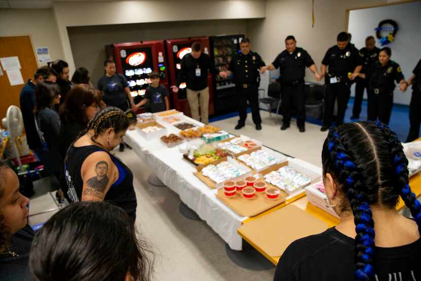 Valerie Zamarripa with family members prays with the Dallas Police Southwest Patrol division...