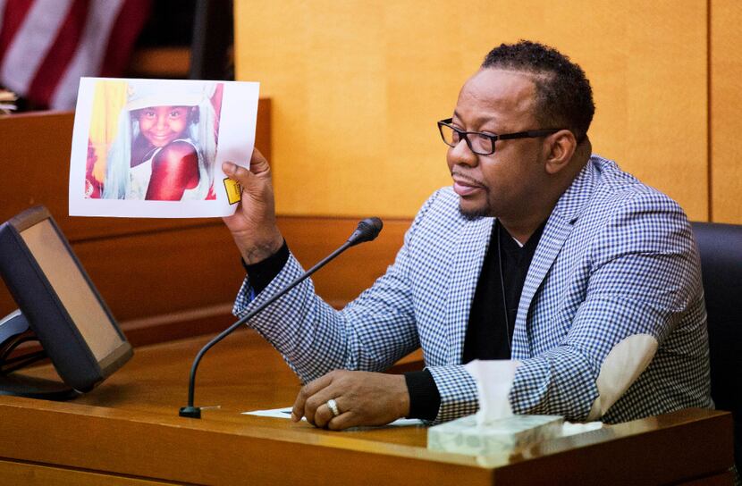 Bobby Brown holds up a picture of his daughter, Bobbi Kristina Brown, during a wrongful...