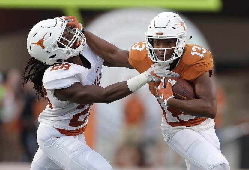 Texas wide receiver Jerrod Heard (13) is hit by defensive back Jarmarquis Durst (28) after...