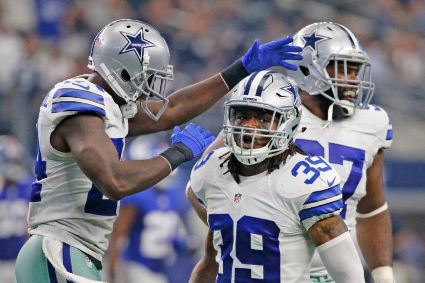 Dallas Cowboys cornerback Brandon Carr (39) is congratulated by teammates after a...