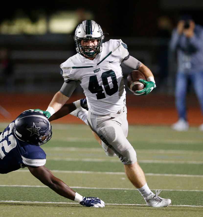 Frisco Reedy's Will Harbour (40) stiff arms Frisco Lone Star's Nicholas Bolton (32) on a run...