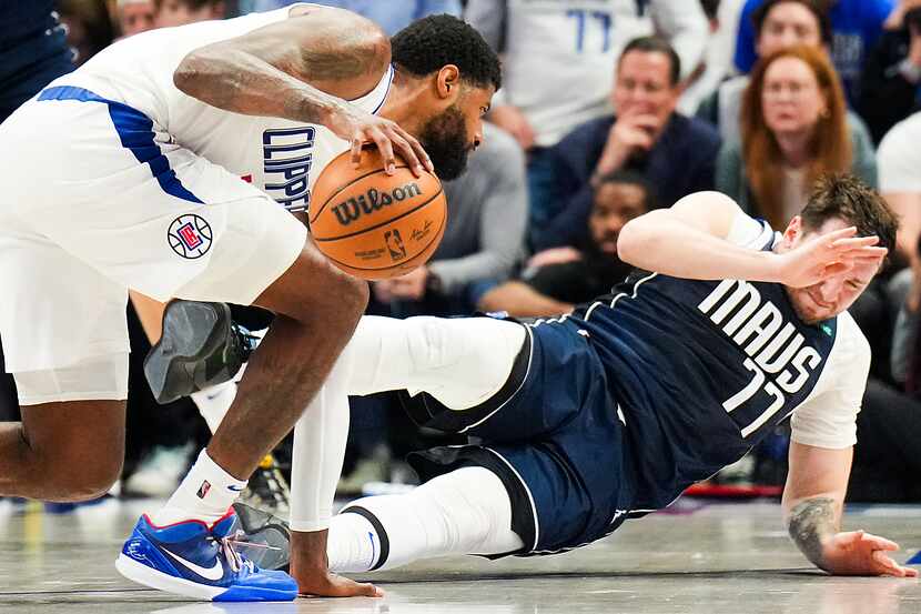 Dallas Mavericks guard Luka Doncic (77) falls to the floor as he collides with LA Clippers...