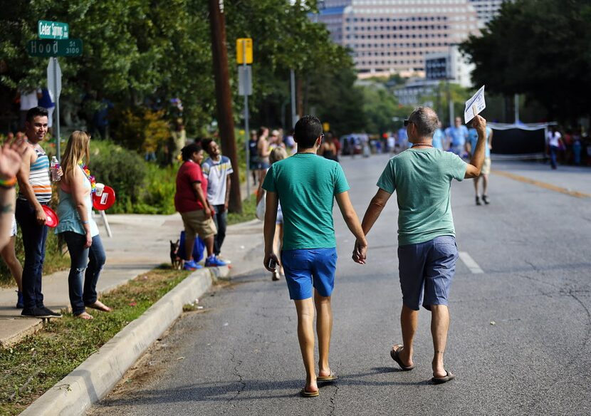 A couple walks to the festival in Lee Park after attending the Alan Ross Texas Freedom...