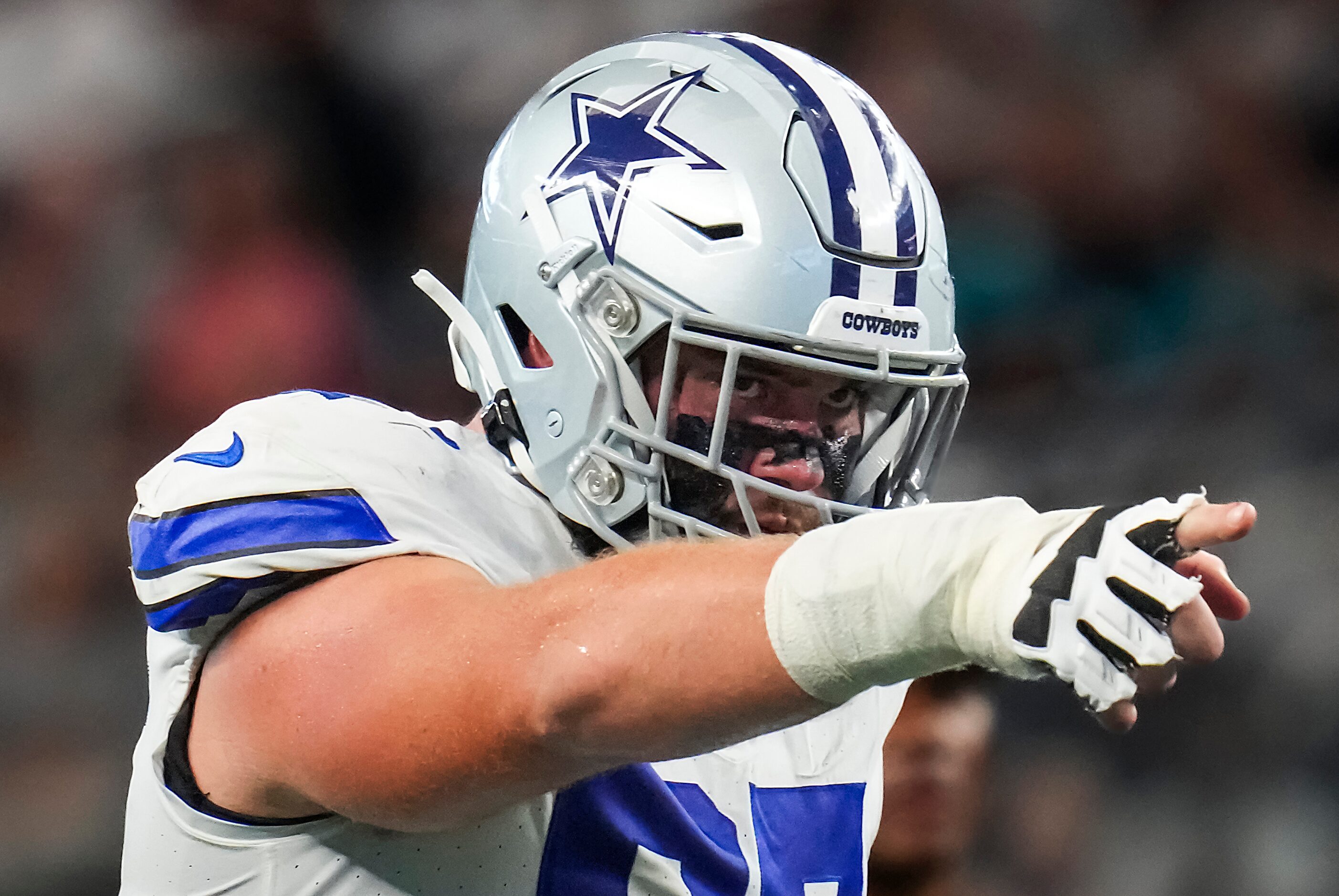 Dallas Cowboys center Brock Hoffman points to a defender as he comes to the line of...