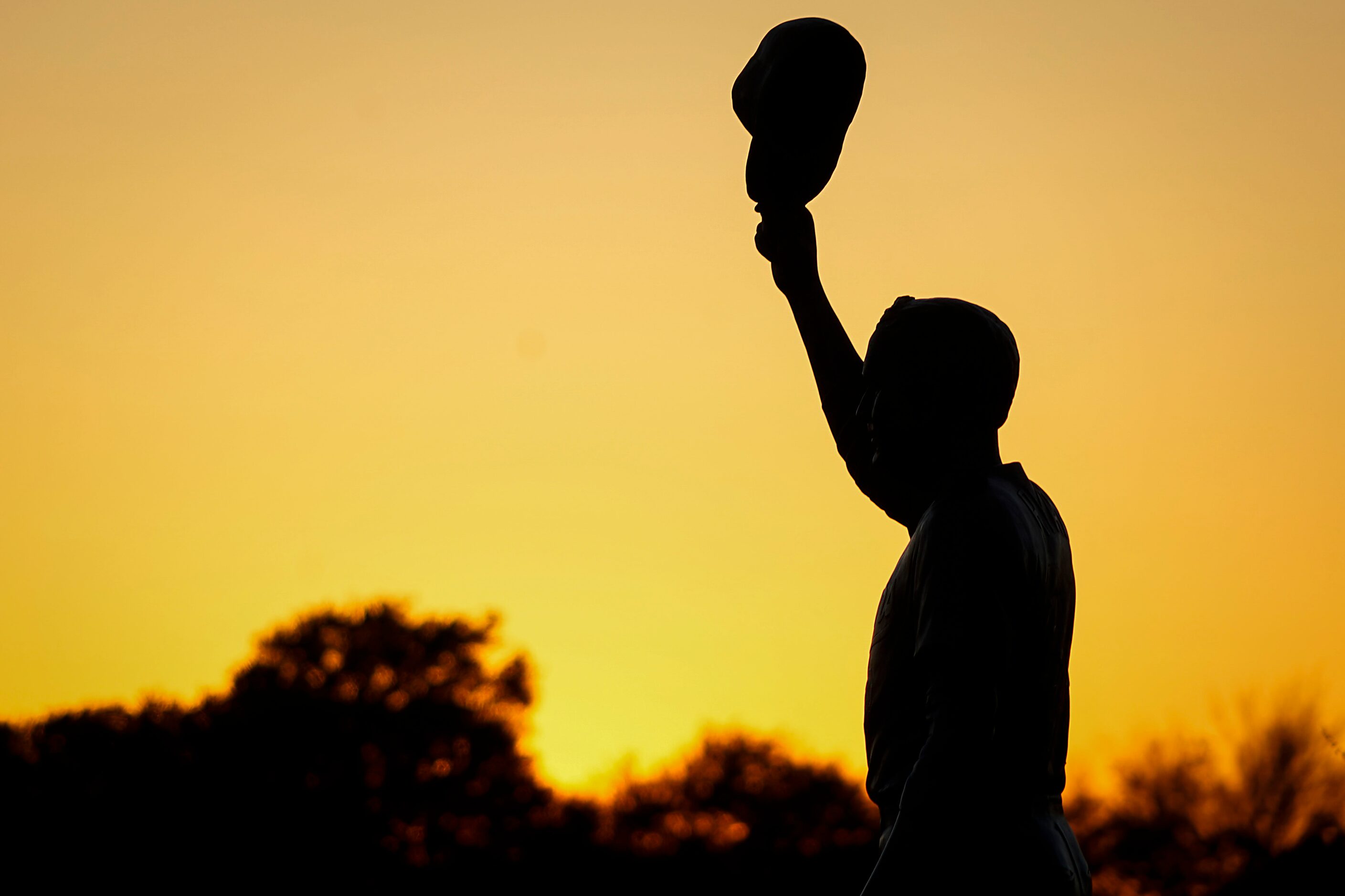 The sun sets behind a statue of Nolan Ryan outside Dell Diamond during the season opener...