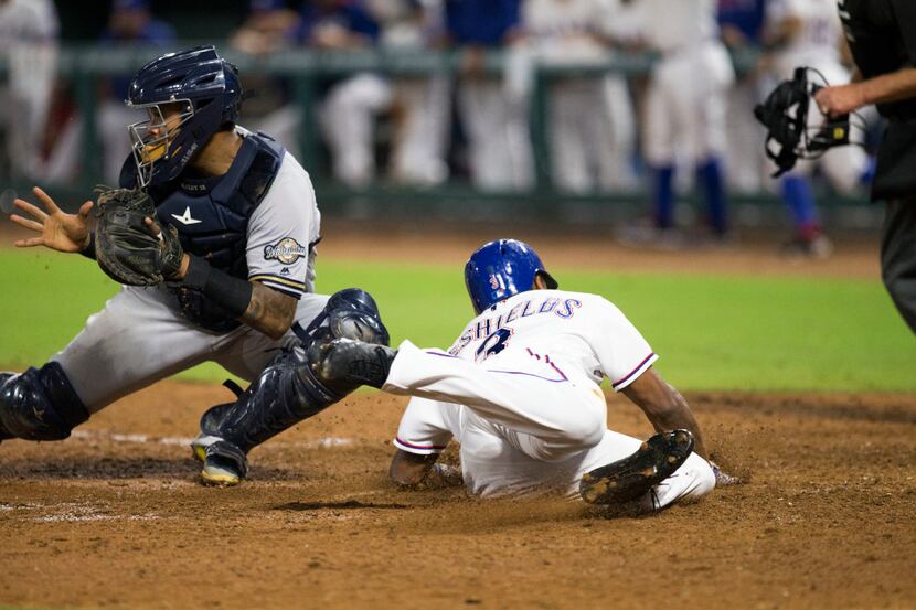 Texas Rangers center fielder Delino DeShields (3) slides into home plate after an RBI by...