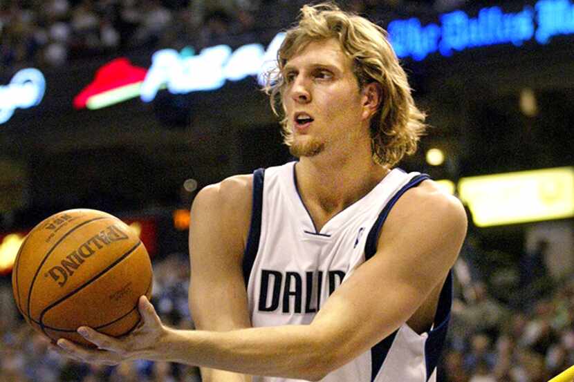  November 30, 2002--Dallas' Dirk Nowitzki appears to do double duty as he uses a floor mop...