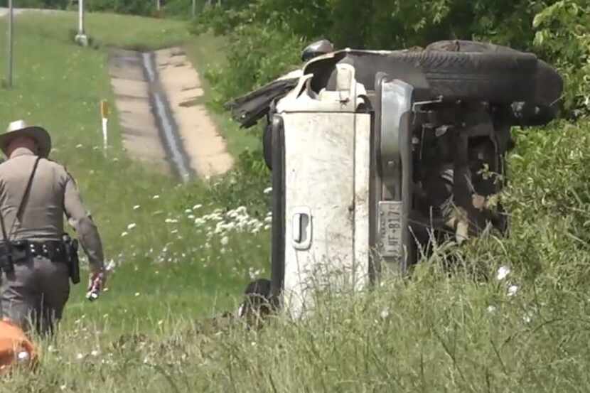 A DPS trooper looks over an overturned pickup that crashed along Highway 67 in Keene after a...