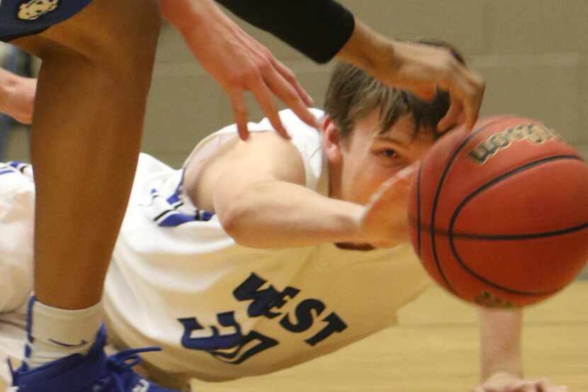 Plano West guard John David Zogg (30) keeps his concentration as he reaches for a rebound...