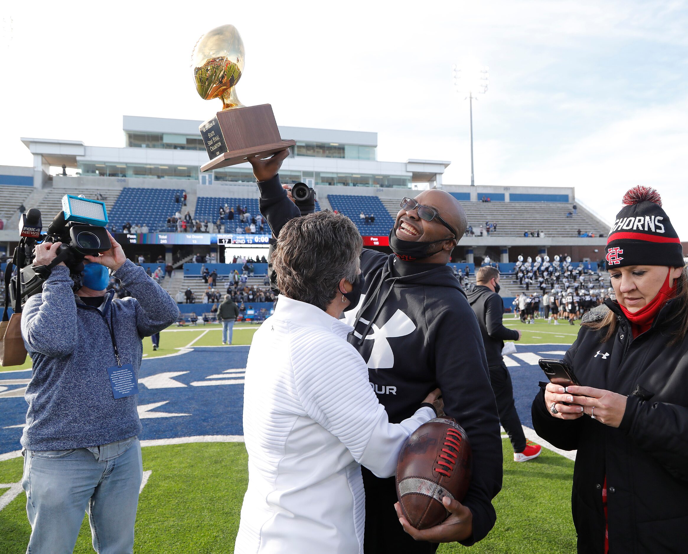 Cedar Hill High School head coach Carlos Lynn hoists the trophy after the win as Denton...