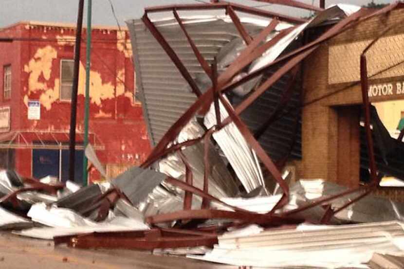 Twisted steel beams and siding lie in a street Tuesday in downtown Mineral Wells after a...