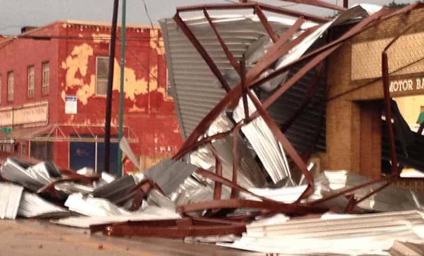 Twisted steel beams and siding lie in a street Tuesday in downtown Mineral Wells after a...