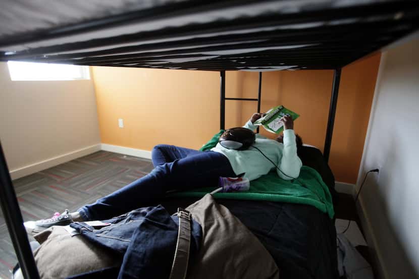 A 13-year-old girl relaxes on a bed at Promise House, which is a Dallas nonprofit that helps...